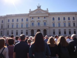 Diferite persoane privind spre o clădire guvernamentală.